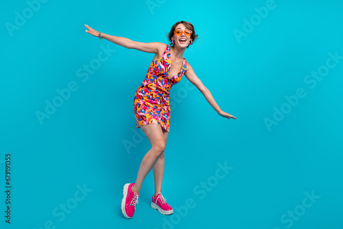 Fototapeta Naklejka Na Ścianę i Meble -  Full length photo of cool carefree girl dressed print outfit dark eyewear dancing having fun isolated blue color background
