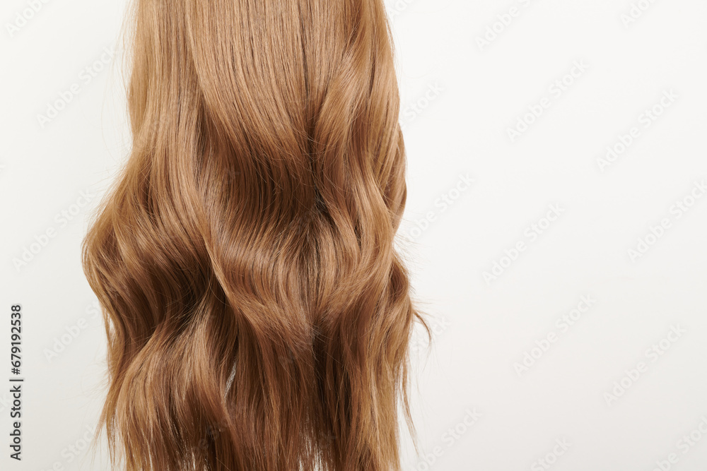 Naklejka premium Natural looking shiny hair, brown curls isolated on white background with copy space