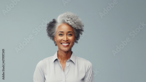 Radiant woman with striking gray hair and a warm smile, dressed in a crisp white shirt