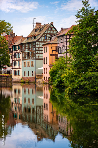 La Petite France is a picturesque “quartier“ in Strasbourg in Alsace, France. Idyllic view of colorful truss houses on the waterfront of old town channel system. Major tourist destination and sight.