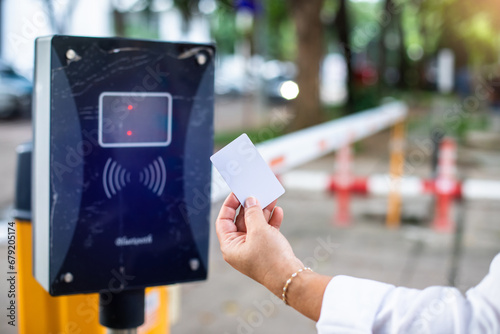 Selective focus to RFID reader with blurry RFID card in hand of driver for automatic barrier gate system. Parking and automatic payment system with licence plate recognition. photo