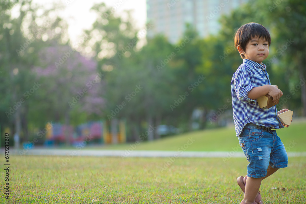 Asian preschool boy enjoying outdoor recreation city park sunset light