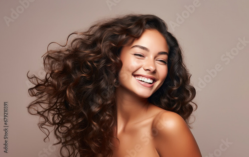 Smiling Young Woman With Thick Flowing Curly Brown Hair on a Pastel Beige Background