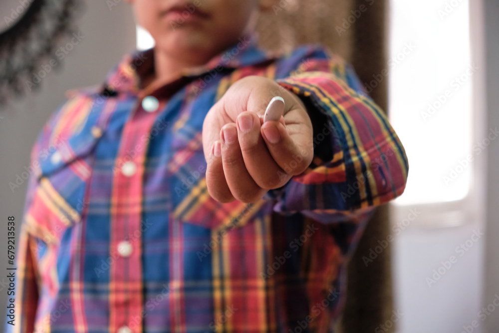 Young Latin Child Holding a White Medicine Pill