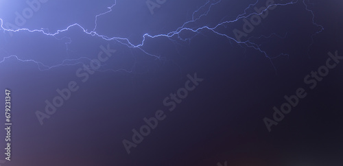 Lightning from the black and blue sky. Storm clouds.