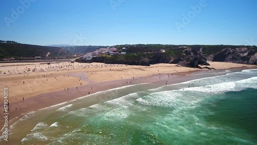 Aerial video filming by drone of the sea bay and beach near the village of Odeceixe Alentejo Portugal. Beach with tourists in the background.
