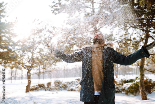 Cheerful man enjoying a cold snowy day. Stylish man spends time outdoors. Season, Christmas, travel.