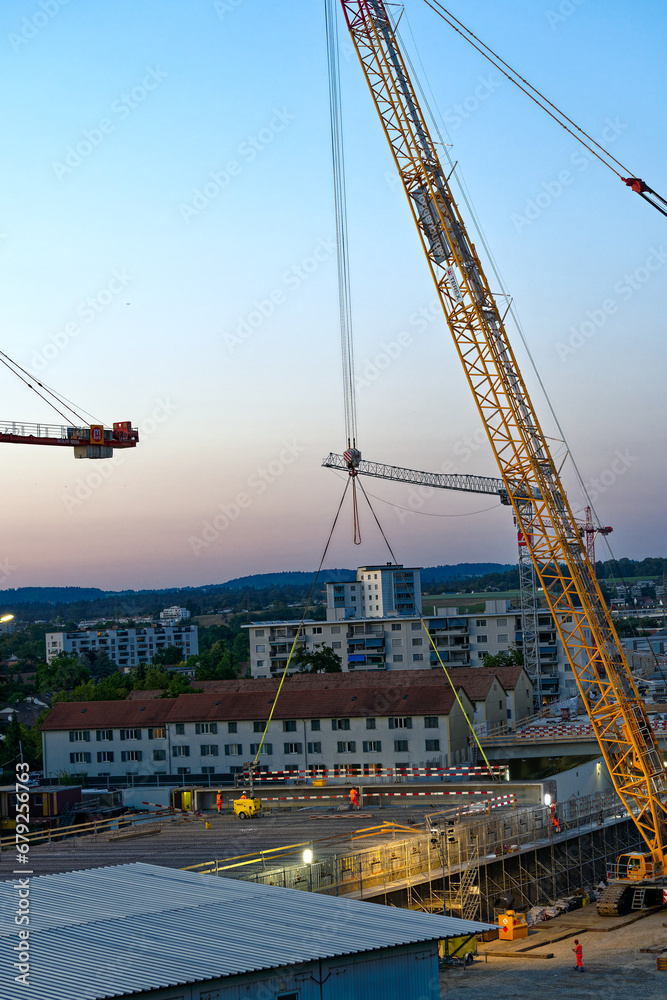 Mobile crane lifting and placing girder at highway enclosure construction site at City of Zürich on a beautiful late spring evening. Photo taken June 13th, 2023, Zurich, Switzerland.