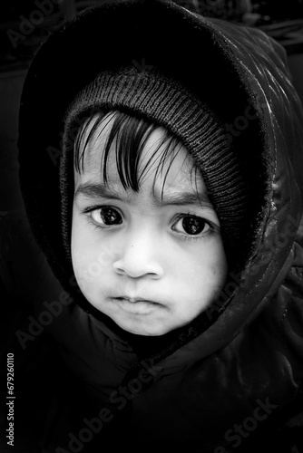 Black and white portrait of an Asian boy wearing a winter hoodie.