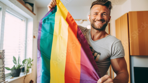 smiling gay men with gay pride flag at home photo
