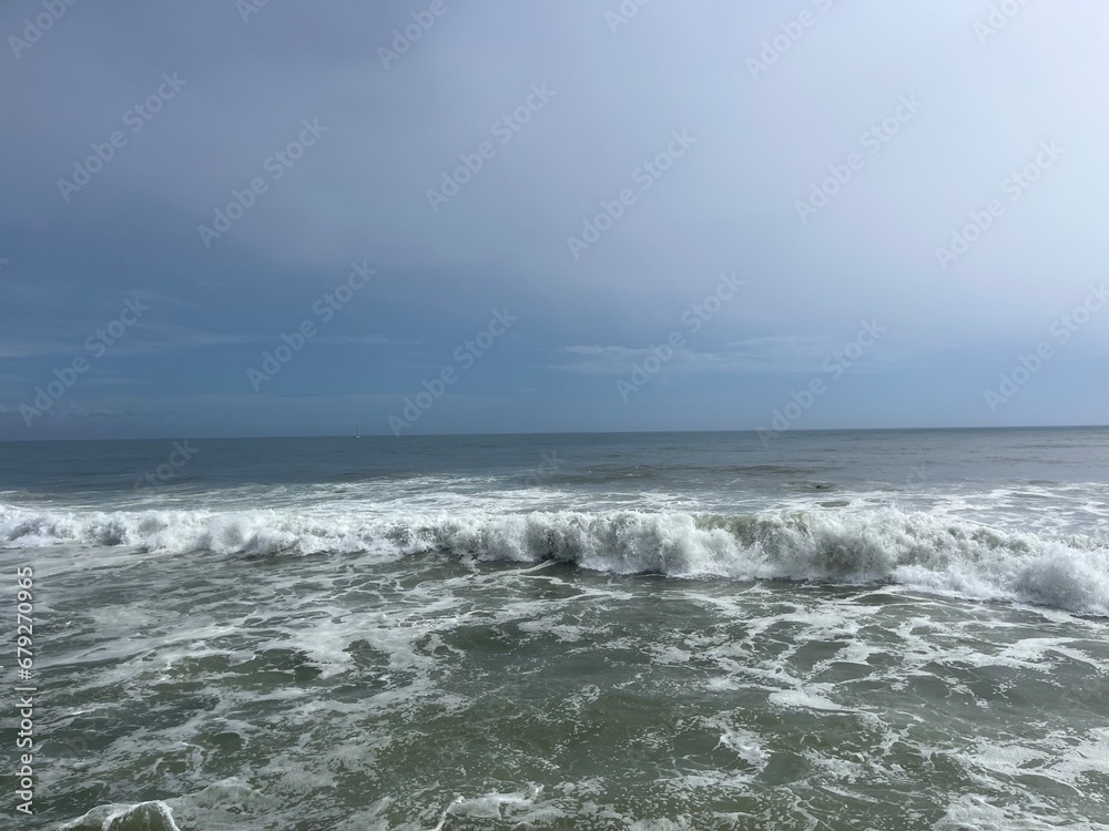 Rainy cloudy sky at the sea, waves sea horizon, gray seascape, foam at the water