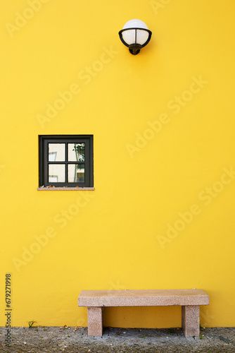 Maison de vile au mur jaune et banc de marbre sous une lanterne. Seia, Serra da Estrela, Portugal.