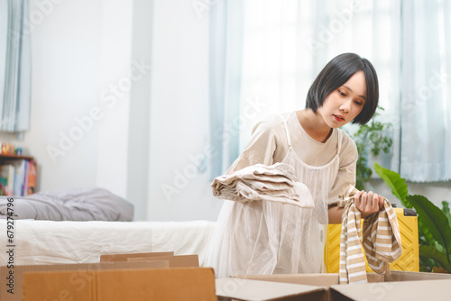 Woman unpack carton box in bedroom moving house to new home or apartment © dodotone