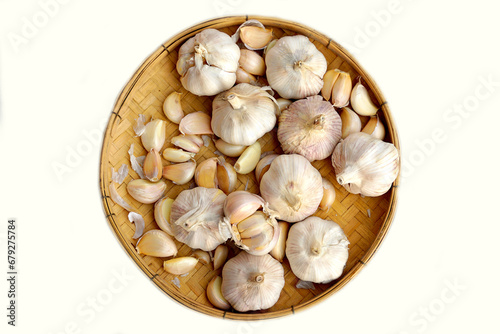 Garlic in a bamboo basket on a white background It is a medicinal plant in Thai kitchens used as an ingredient in food. It has a pungent odor and a spicy taste. It can be eaten both fresh and cooked.
