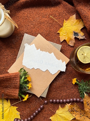 The image shows a notebook, cup of coffee, and flowers on a sweater. 