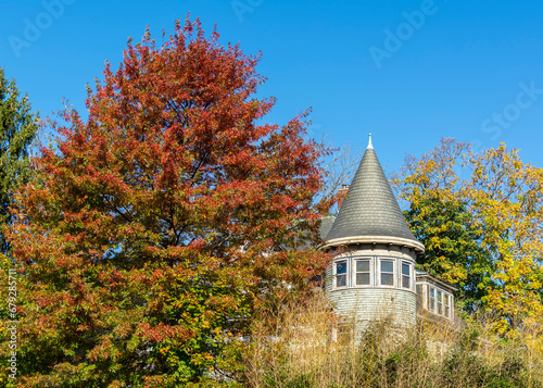 Old house with conical roof surrounded by autumn trees on a sunny day  Boston  Massachusetts  USA