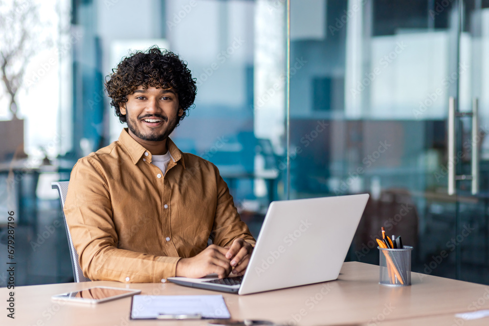 Portrait of young successful businessman inside office at workplace, hispanic smiling and looking at camera, male programmer happy with achievement results. Portrait of young successful businessman inside office at workplace, hispanic smiling and looking at camera, male programmer happy with achievement results.