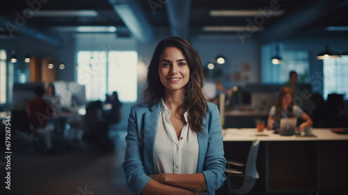 Portrait of smiling businesswoman standing with arms crossed in creative office