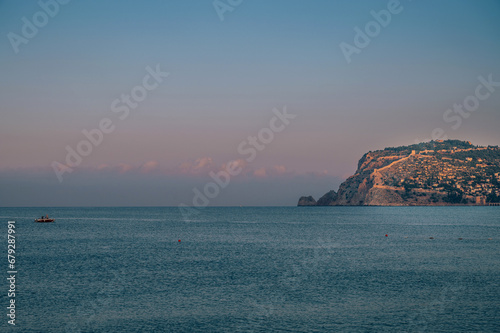 Fototapeta Naklejka Na Ścianę i Meble -  Beautiful sunrise scene on Alanya beach with view to famous Alanya island, in Turkey