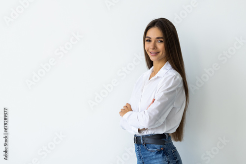 Portrait of woman standing with arms folded isolated on a white background photo