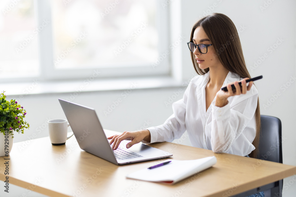 Portrait of attractive positive lady sit chair use phone write typing modern office indoors Portrait of attractive positive lady sit chair use phone write typing modern office indoors