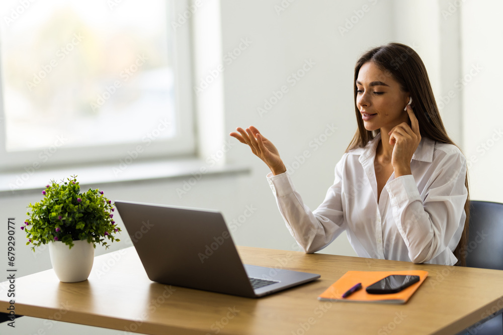 Businesswoman with video call headset working in modern office. online customer support worker using laptop. Businesswoman with video call headset working in modern office. online customer support worker using laptop.