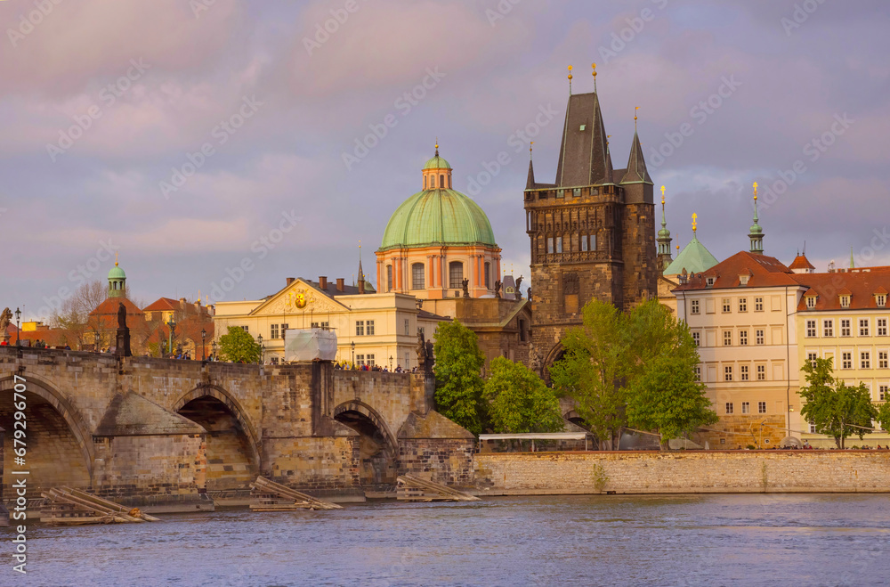 View of old town with Charles Bridge (Karluv Most) on Vltava river and Old Town Bridge Tower, famous tourist destination in Prague, Czech Republic (Czechia), at sunset