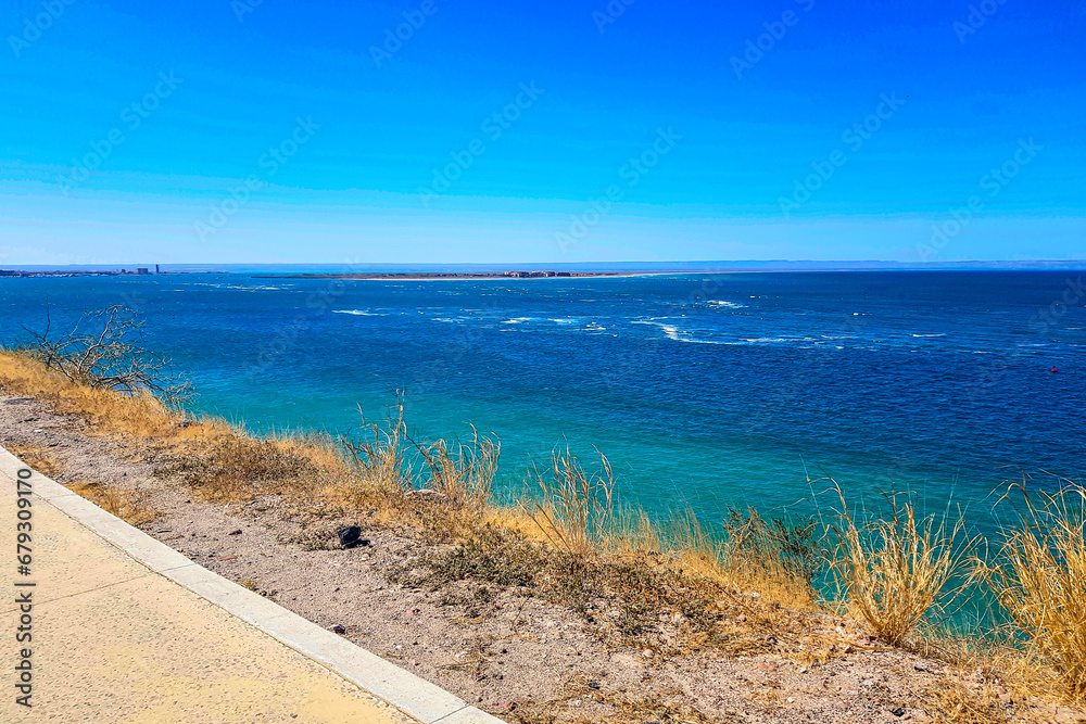 Panoramic view of Sea of Cortez with blue waters with peninsula in background, seen from a tourist viewpoint on mountain, sunny spring day in La Paz, Baja California Sur Mexico