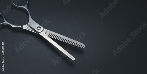 Professional Haircutting Scissors. Open hairdresser scissors on a black background. Professional tool for hairdressers scissors.