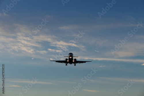Airplane in the blue sky at sunset with clouds in the background