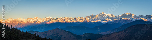 Panoramic view during sunset over snow cladded gangotri group mountain peaks falls in Greater Himalayas mountain range from Chopta, Uttarakhand, India.