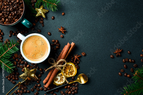 A cup of coffee on a table with New Year and Christmas decorations. Top view, on a black background, free copy space. Holiday.
