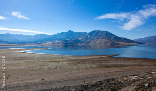 Shallow mountain lake, dry tree trunks at the bottom of a dry lake