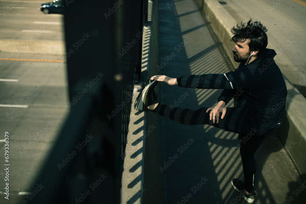 Man Stretching During an Urban Outdoor Workout Man Stretching During an Urban Outdoor Workout