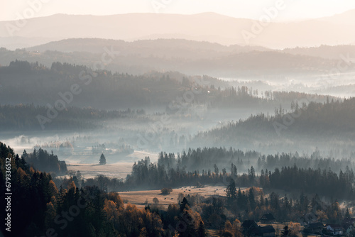 Krajobraz jesienny w Beskidach. Mgliste góry o świcie. Relaks, wypoczynek i pastelowy wschód słońca.