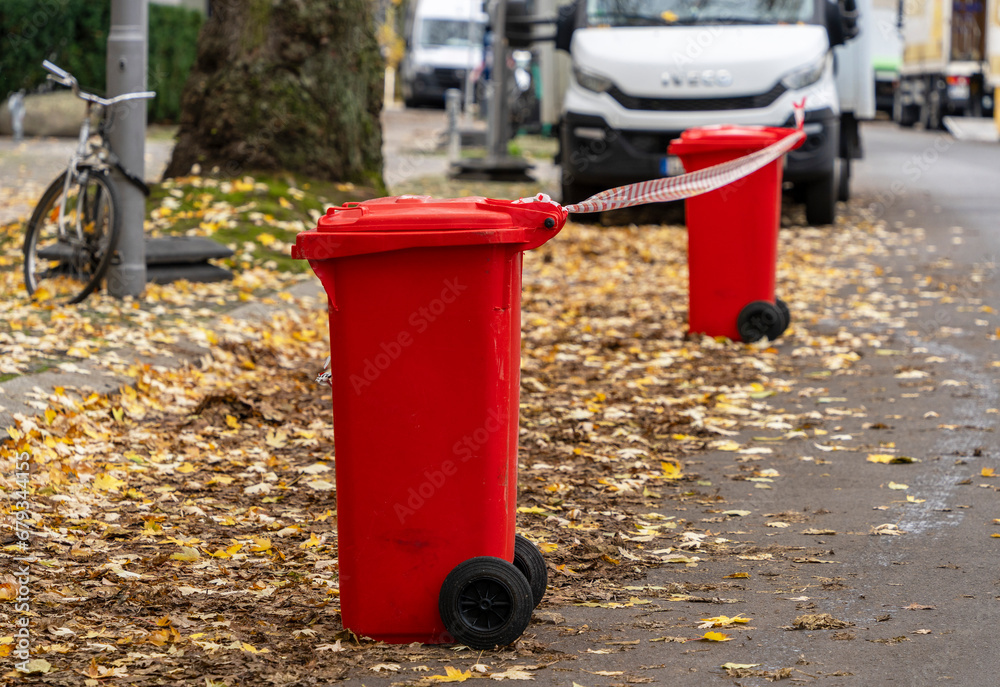 Absperrung, rote Mülltonnen mit rot-weißem Absperrband, Berlin, Deutschland Absperrung, rote Mülltonnen mit rot-weißem Absperrband, Berlin, Deutschland