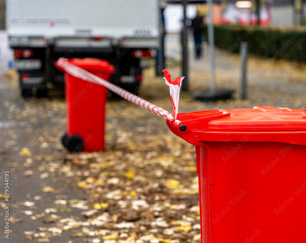 Absperrung, rote Mülltonnen mit rot-weißem Absperrband, Berlin, Deutschland Absperrung, rote Mülltonnen mit rot-weißem Absperrband, Berlin, Deutschland