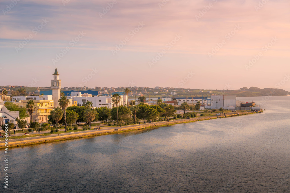 The scenic panorama of Bizerte, the city in Tunisia, with the Mediterranean sea, mosque minaret, and people on the waterfront.