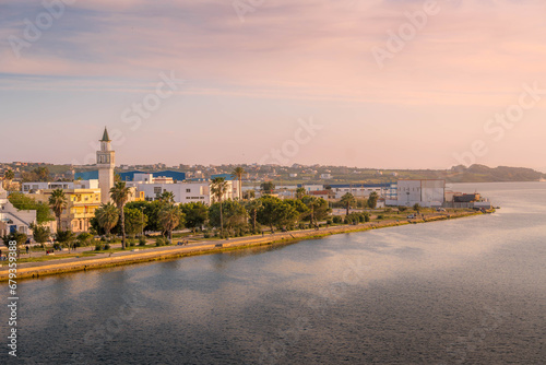 The scenic panorama of Bizerte, the city in Tunisia, with the Mediterranean sea, mosque minaret, and people on the waterfront. photo