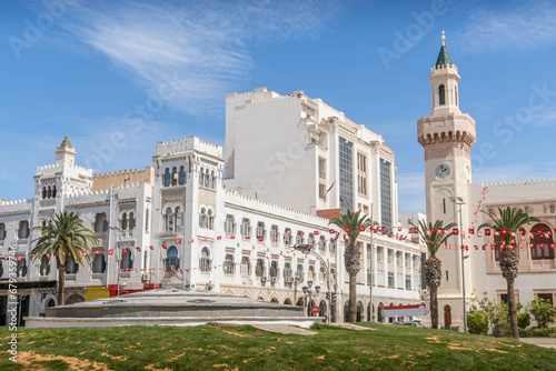 The white-painted colonial architecture buildings in the downtown of Sfax, Tunisia, with the Tunisian flags, beautiful balconies, and the small park.