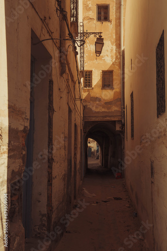 The narrow street with the lamp and small windows at old town (Medina) of Kairouan, Tunisia, in the Maghrib region of Africa. photo