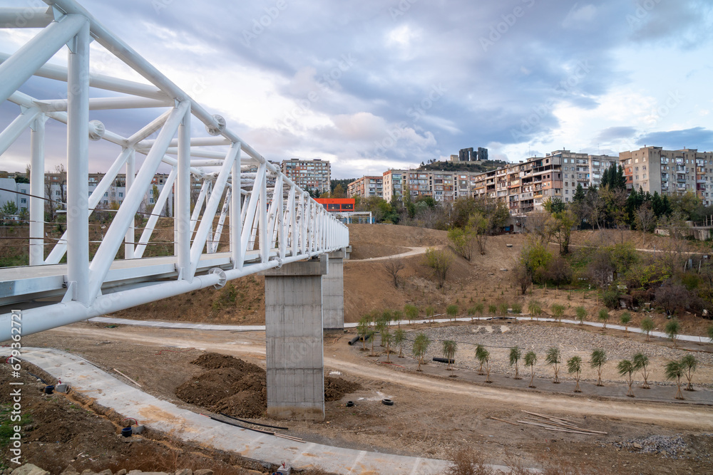 Iron pedestrian bridge over a small canyon painted in white. Tbilisi Iron pedestrian bridge over a small canyon painted in white. Tbilisi