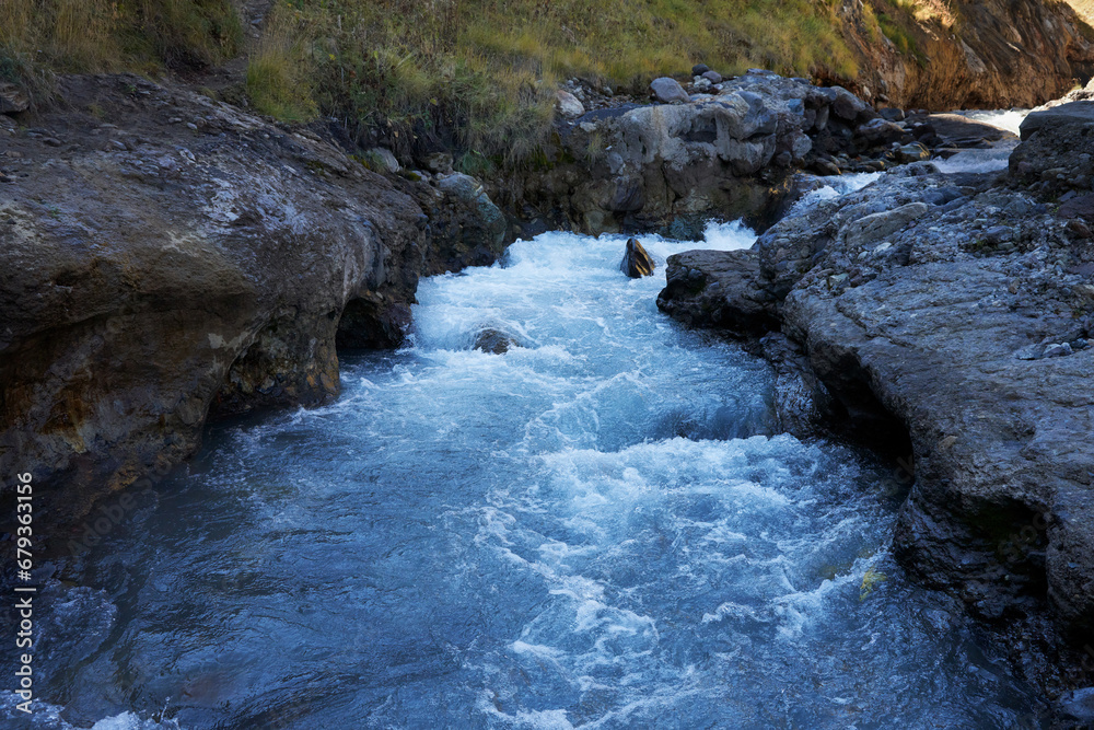 A mountain river with a rocky bed and fast flowing water. A mountain river with a rocky bed and fast flowing water.