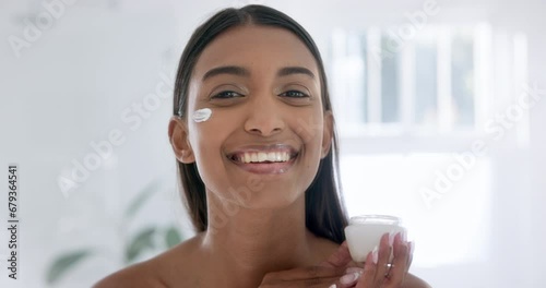 Woman, face cream and smile in bathroom with portrait, skincare or moisturizer for hydrated skin. Beauty model, indian and retinol with collagen booster, self-care and hyaluronic acid serum for pores