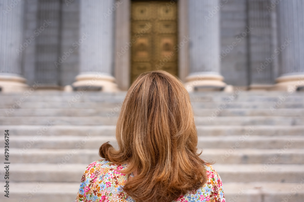 Woman with her back turned in front of the stairs of the main facade of the Congress of Deputies Madrid, Spain