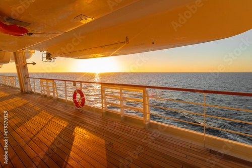 Pont promenade d'un navire de croisière en navigation au coucher de soleil.	
