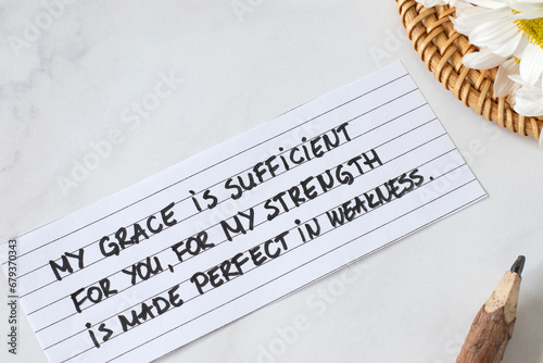 My grace is sufficient to you, for My strength is made perfect in weakness, handwritten Christian quote with flowers and pencil. Faith, trust, and peace in God Jesus Christ (2 Corinthians 12:9 verse). photo