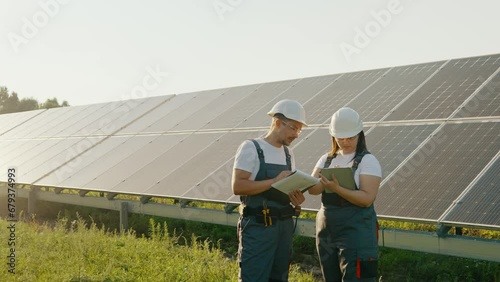 Technicians with tablet checking the operation of solar energy panels