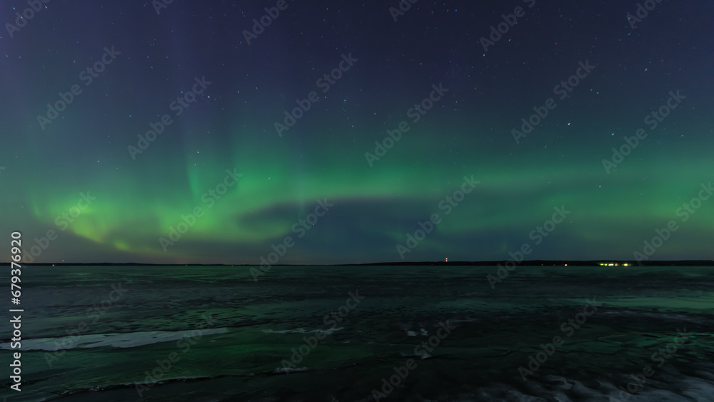 Green aurora borealis over a frozen lake in Tampere, Finland