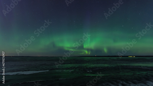 Green aurora borealis over a frozen lake in Tampere, Finland © Jani Katajisto